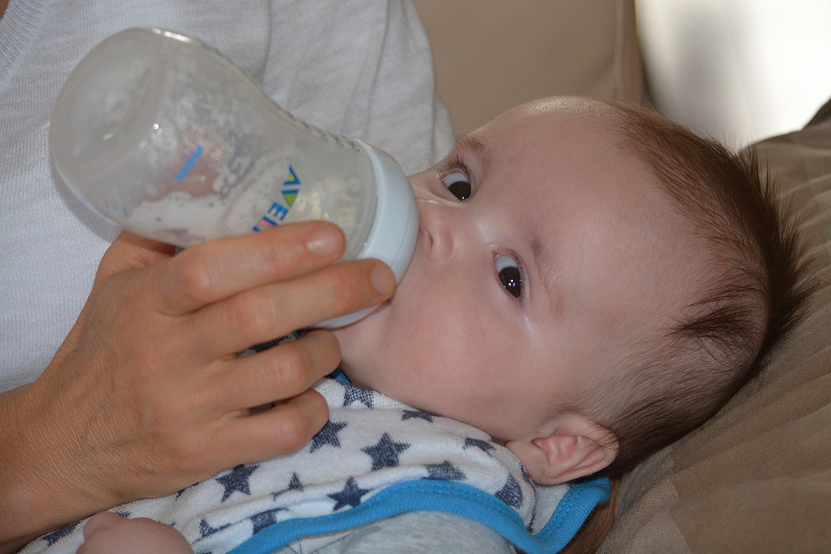 Baby wird mit Flasche gefüttert. 