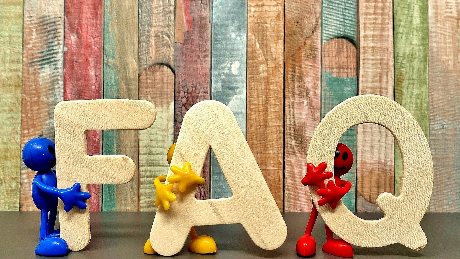 Die Buchstaben F, A und Q werden von Spielfiguren gehalten. 