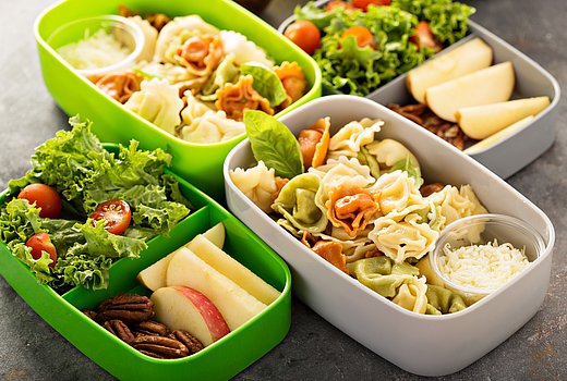 Lunchboxen mit Nudelsalat und grünem Salat