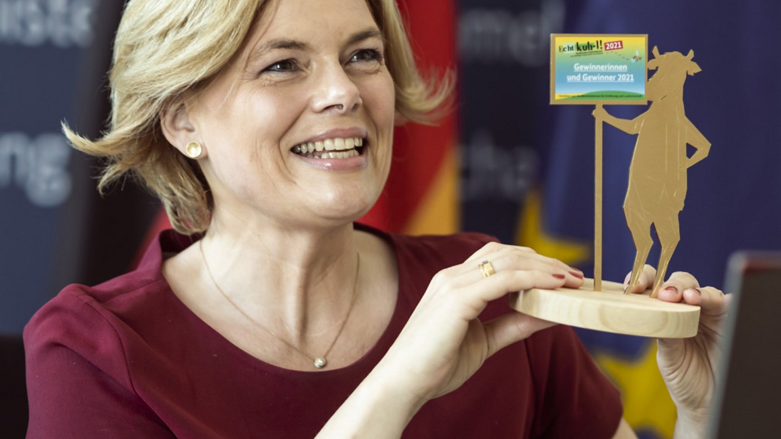 Bundesernährungsministerin Julia Klöckner hält die Trophäe für den Schulwettbewerb Echt kuh-l in der Hand.