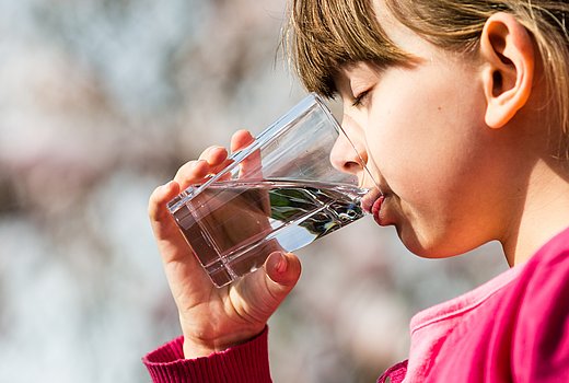 Kind trinkt Wasser aus einem Glas