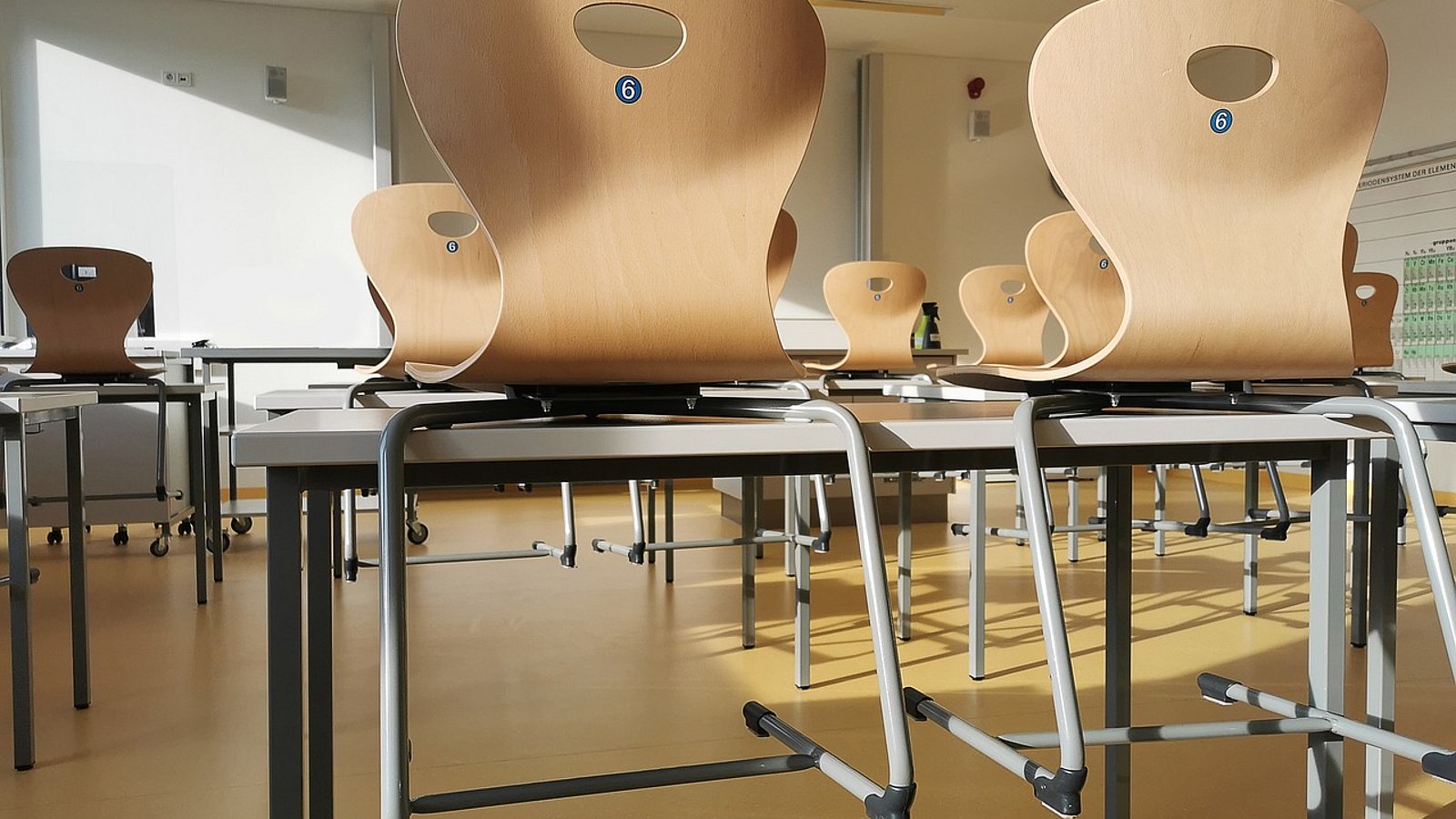 Ein leerer Klassenraum mit hochgestellten Stühlen.