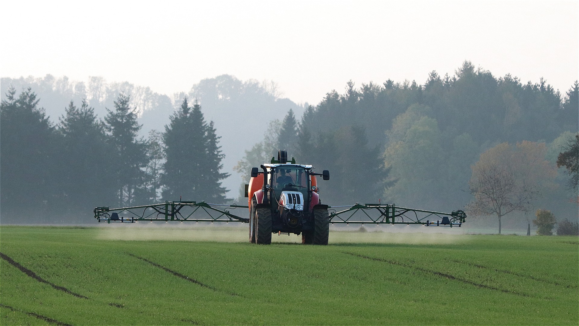 Traktor versprüht Pflanzenschutzmittel auf einem Feld